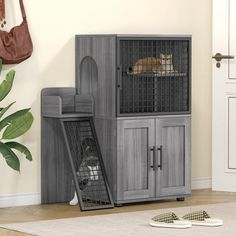 a dog laying on top of a cage in front of a wall mounted cat litter box