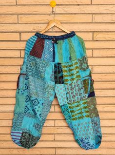 a colorful patchwork pants hanging on a brick wall