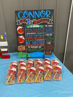 a table topped with lots of lollipops next to a chalkboard sign