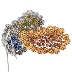 Revel in the beauty of thoughtfully crafted pieces in our new collection, where elegance meets heritage in the form of the 18K Two Tone Oversized Sapphire, Ruby, Emerald, and Diamond Brooch. This vintage estate treasure exudes timeless allure, boasting an intricate design of three-dimensional leaves, each adorned with a delicate flower motif set in a diamond border. The harmonious blend of 18 karat yellow and white gold adds a touch of sophistication to this exquisite brooch, making it a true statement piece.As you explore this brooch, you'll discover approximately 250 round diamonds that sparkle brilliantly, enhancing the overall glamour of the design. The focal point shines with 12 carats of oval-cut rubies, 10 carats of oval-cut blue sapphires, and approximately 6.50 carats of oval-cut Luxury Multicolor Gemstone Brooches, Luxury Multi-stone Brooches For Anniversary, Luxury Jeweled Brooches, Elegant Multicolor Gemstone Brooches, Elegant Multi-stone Brooches For Formal Occasions, Elegant Diamond Multi-stone Brooch, Fine Jewelry Multi-stone Wedding Brooches, Luxury Diamond Jeweled Brooches, Luxury Diamond Brooches With Jewels