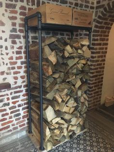 a pile of wood sitting on top of a metal rack next to a brick wall