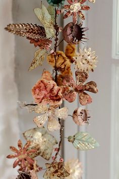 a wind chime with dried flowers and leaves hanging from it