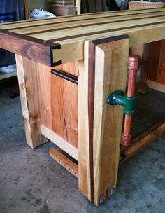 a workbench made out of wooden planks with a pipe running through it