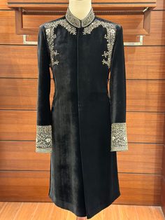 Our black velvet sherwani, a masterpiece in pure shaffon silk velvet. The richness of this fabric allows it to embrace any colour, a testament to its pureness and versatility. Immerse  yourself in the opulence of premium-quality velvet, as showcased in the captivating images. Adorned with intricate zardozi hand stitched work on the shoulders, collar and cuffs, our commitment to excellence shines through. No shortcuts -- every detail is fully stitched with a blend of different zari materials, ens Velvet Long Sleeve Traditional Wear For Weddings, Velvet Nehru Jacket Men, Traditional Velvet Kurta For Formal Occasions, Traditional Formal Velvet Kurta, Black Sherwani For Winter Wedding, Velvet Kurta For Wedding And Eid, Black Wedding Sherwani For Winter, Black Winter Wedding Sherwani, Ceremonial Black Sherwani With Dabka Work