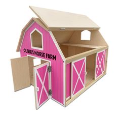 a wooden dollhouse with pink painted doors and windows on the side, including an open door