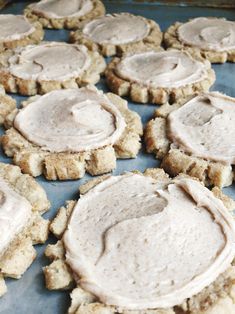 some cookies with frosting on them sitting on a cookie sheet