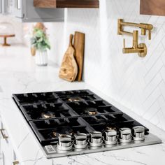 a stove top oven sitting inside of a kitchen next to a wooden cutting board and utensils