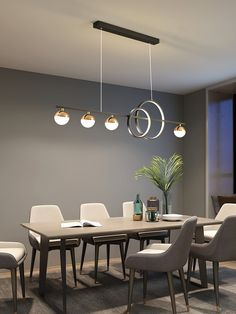 a dining room table and chairs with lights hanging from the ceiling