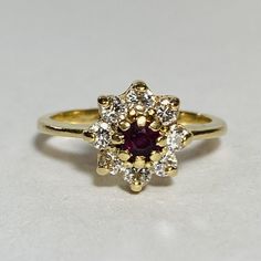 GG Certified 14K Yellow Gold Ruby Diamond Ring Size 6 1 Round faceted ruby, measuring approx. 4.29 mm Color: Deep purplish-red Transparency: Transparent Approx. total carat weight: 0.40ct * Natural ruby 8 Round brilliant cut diamonds, measuring approx. 2.50 mm Color: H-J Clarity: VS-SI Approx. total carat weight: 0.48ctw * Natural diamond Approx. measurements: 10.34 x 10.37 x 6.77 mm Approx. shank width: 1.86–1.20 mm Setting composition: 14K gold (stamped 14K) Finish: Polished Approx. gross weig Ruby Diamond Ring, Ruby Diamond Rings, Ruby Diamond, Natural Ruby, Diamond Sizes, Round Brilliant Cut Diamond, Round Brilliant, Natural Diamonds, Diamond Ring