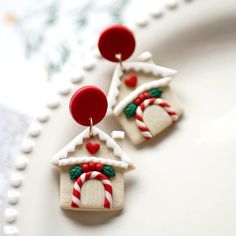 two small christmas houses with candy canes on them are sitting on a white plate