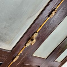 two wooden doors with brass handles and decorative knobs