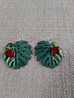 These leaf earrings are hunter green with light green accents and ladybug glass murrini.  They are hanging from sterling silver wires. Ladybug Earrings, Green Accents, Phoenix Az, Leaf Earrings, Hunter Green, Silver Wire, Light Green, Jewelry Earrings Dangle, Phoenix