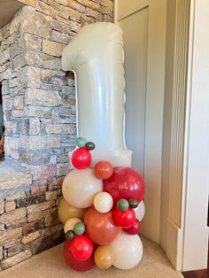 a bunch of balloons sitting in front of a brick wall next to a fireplace with a blow dryer on top