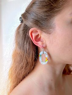 a close up of a person wearing some kind of earring with flowers on it