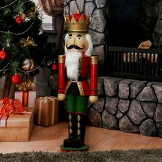 a nutcracker standing in front of a christmas tree with presents around it and a fireplace