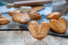 several pastries sitting on a cooling rack with powdered sugar sprinkled on them