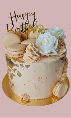 a birthday cake with frosting and flowers on the top is decorated with gold foil