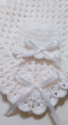 a white crocheted hat with bows on it