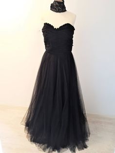 A stunning full length strapless Black Dress with matching Black Lace Choker. The dress has an elegant Sweetheart neckline with ruffled trimming. The bodice is elegantly ruched. The skirt of the dress is A-line and suits any figure. It is a full, but not puffy tulle skirt. The lace choker adds that extra UMPH to the dress. Its quite a thick choker, which gives it a unique appearance. Quite a statement maker! Size:  EU: 36/38 UK: 8/10 US: 4/6 Black Ruched Evening Dress With Sweetheart Neckline, Black Evening Dress With Ruched Sweetheart Neckline, Black Strapless Evening Dress With Ruched Bodice, Black Evening Dress With Sweetheart Neckline And Ruched Detail, Evening Strapless Ball Gown With Ruffles, Strapless Tulle Evening Dress With Ruched Bodice, Black Prom Gown With Ruched Bodice, Formal Tulle Strapless Dress, Black Strapless Dress With Pleated Bodice