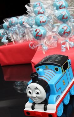 thomas the tank engine cake pops on a table with red and blue lollipops