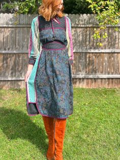 This vintage 70s homemade folk dress is truly a work of art, made with so many thoughtful, exquisite details. Somewhere between a Bill Tice and Young Edwardian, there are so many lovely design features, like the quilting on the front and back yoke. The contrast color fabric is such a thoughtful choice by someone who truly loved garment making. And can we talk about the asymmetrical cutout on the neckline with decorative beaded cord? It's obvious that had fun choosing these playful design elements! Impeccable dark purple tipping along every seam. The jacquarded fabric sleeves and inset side panels in turquoise, plum and soft citron are such a beautiful complement to the moody, dark floral print on the front and back. A gorgeous straight silhouette that looks great with or without the belt. Multicolor Retro Silk Dress, Retro Multicolor Silk Dress, Traditional Green Fall Dresses, Retro Patchwork Dress For Fall, Multicolor Long Sleeve Dress With Vintage Print, Multicolor Long Sleeve Dresses With Vintage Print, Bohemian Silk Midi Dress For Fall, Vintage Multicolor Patchwork Dresses, Fitted Floral Patchwork Dress For Fall