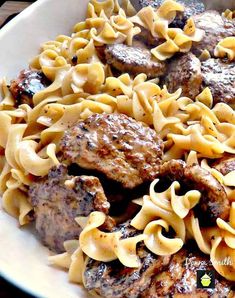 a white bowl filled with pasta and meat