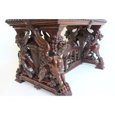 an ornate wooden table with carved animals on it's sides and carvings around the edges