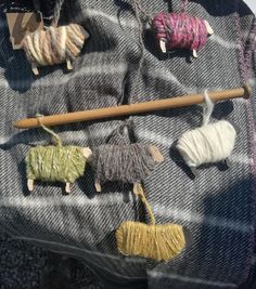 yarn and wooden animals are displayed on a blanket