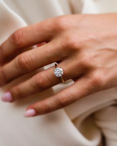 a woman's hand with a diamond ring on it