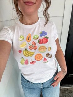 Embrace the charm of our vintage fruit collage top, a y2k inspired baby tee featuring a delightful collage of painted fruits. This isn't just any fruit graphic tee--it's a girly top perfect for adding a touch of nostalgia to your wardrobe. With its playful design and farmers market vibes, it's a nod to 90s fashion that's both fresh and timeless. Click now to add it to your cart and elevate your style! 🫧 SIZING * Available sizes: XS -XL  * This garment is true to size, but size down if you prefer a more fitted look. * Keep in mind, this garment is in youth sizing to achieve the baby tee fit, so it will be more snug around the bust. * Refer to the size chart in the photos for details, we recommend measuring a shirt you already own and love in order to get the perfect fit. 🫧 MATERIALS * 100 Scrapbook Aesthetic, Fruit Collage, Fruit Graphic, Girly Tops, Fruit Shirt, Vintage Fruit, Aesthetic Shirt, Y2k Baby Tee, Fruit Illustration