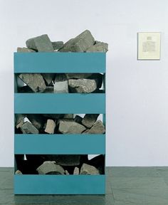 a stack of rocks sitting on top of a blue shelf next to a white wall