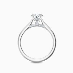 a white gold ring with a diamond on the top and side stones in the middle