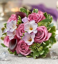 a bouquet of pink roses and orchids on a table with a good morning sign