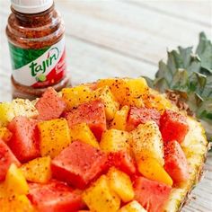 pineapple and watermelon salsa in a pineapple bowl next to a jar of salsa