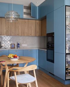 a kitchen with blue cabinets and wooden floors