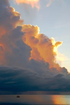 a boat is out on the water under some clouds