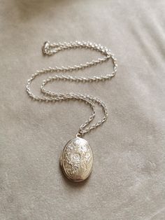 Vintage silver plated brass carved locket necklace on textured silver plated brass chain.  Chain is 49cm (19") long  and has a lobster clasp clossure. The locket is 35mm x 22mm and can be opened: you can put photos of your beloved ones inside. Due to genuine vintage nature, the back of the locket has some minor stains and scratches, please see last picture. This is OOAK piece. This is a great gift for mothers, grandmothers, sisters and aunts. It comes with a jewelry pouch. Locket Necklace, Photo Picture Locket Necklace, Locket Necklace Silver, Locket Necklace Vintage, Necklace Photo, Silver Locket Necklace, Picture Locket, Photo Locket Necklace, Silver Locket, Vintage Lockets