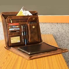 an open wallet sitting on top of a table next to a cell phone and pen