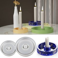 three candles are sitting next to each other on a table with blue and green plates