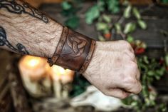 Leather cuff bracelet with the Three Horns of Odin, made of premium leather. The original design of Odin's horns is carefully embossed on the piece, which has been subjected to a handmade aging process identical to those used in Hollywood movies so that the piece seems directly drawn from an epic fantasy story. The size of the laced version ranges from 17 to 22 cm If your size varies from these measures please contact us before buying. The price is for a single bracer. Handmade Viking Leather Bracelet, Adjustable Viking Leather Bracelet, Adjustable Viking Style Leather Bracelet, Adjustable Leather Viking Bracelet, Horns Of Odin, Armor Ideas, Celtic Clothing, Viking Pattern, Character Clothes