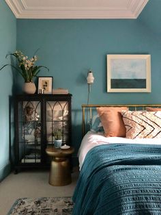 a bed room with a neatly made bed and blue walls