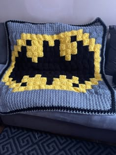 a crocheted batman blanket sitting on top of a couch