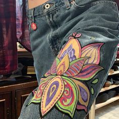 the jeans are decorated with colorful flowers and leaves