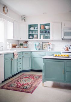 a kitchen with blue cabinets and an area rug