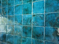 a blue tiled wall with green and white tiles