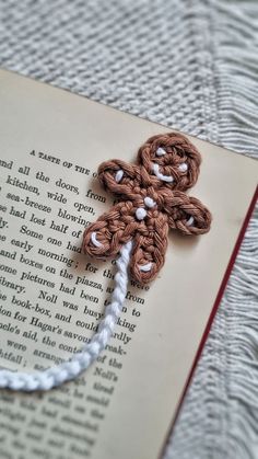 an open book with crocheted flowers on it and a string attached to the page