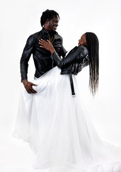 two people dressed in black and white posing for the camera with one woman's back to the camera