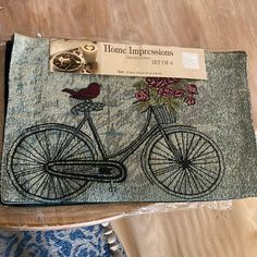 a close up of a piece of cloth with a bicycle and bird on the front