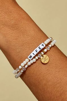 Let’s celebrate all the wifeys in our lives! Gift this handcrafted faux pearl bracelet to the girlie who’s about to wed her prince charming or the woman who’s been happily married for two decades. Part of a Bigger Story: Little Words Project is all about spreading kindness and empowerment through words. By wearing this bracelet, you become part of a larger community that shares the power of words. Bead Pattern: Bling Bling Hand-crafted, faux pearl and crystal beaded bracelet Plated Brass Hardwar Personalized Beaded Wedding Bracelets, Gift Beaded Bangle Bracelet With Pearl Charm, Elegant White Name Bracelet With Letter Beads, Pearl Charm Beaded Bangle Bracelet As Gift, Beaded Bangle Bracelet With Pearl Charm As Gift, Adjustable Pearl Beaded Bracelets For Anniversary, Elegant Beaded Bracelets With Letter Beads For Mother's Day, Elegant Mother's Day Beaded Bracelets With Letter Beads, Adjustable Pearl Charm Bracelet For Wedding