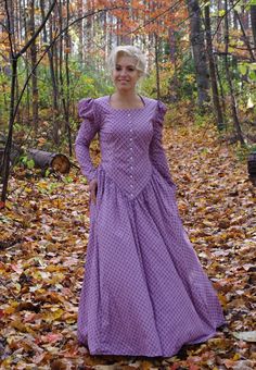 This striking dress has a rounded open neckline, front button closure and leg-o-mutton long sleeves. The waist creates a deep V in the front. This dress also features our three-paneled full skirt with pockets. Hand wash or machine wash and dry gently. 100% sturdy cotton. The model is wearing boots and a crinoline, which are priced separately. Designed and made proudly by Recollections in America! The following are approximate finished measurements and include room for ease of movement.  BustWais Classic Bishop Sleeve Dresses, Regency Style Long Sleeve Fall Dress, Regency Style Long Sleeve Dresses For Fall, Fitted Dresses With Bishop Sleeves And Buttons, Fitted Prairie Dress With Gathered Sleeves, Long Sleeve Fall Costume Dress, Peasant Style Long Sleeve Costume Dress, Regency Style Long Sleeve Prairie Dress For Fall, Classic Fitted Long Sleeve Prairie Dress